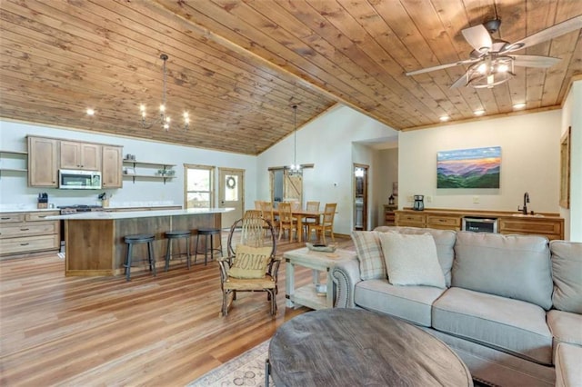 living room featuring vaulted ceiling, light wood-style flooring, ceiling fan with notable chandelier, and wood ceiling