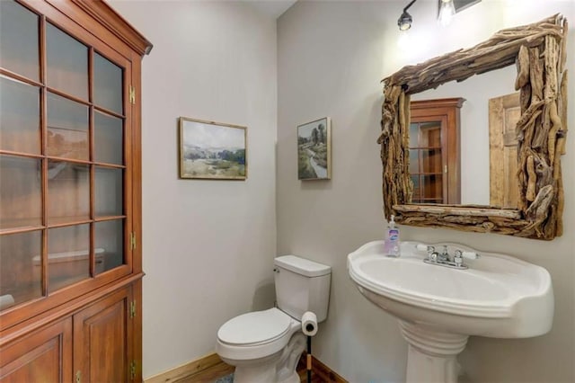 half bath with toilet and baseboards