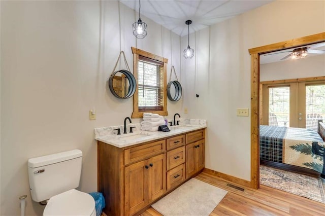 ensuite bathroom featuring visible vents, toilet, ensuite bathroom, a sink, and wood finished floors