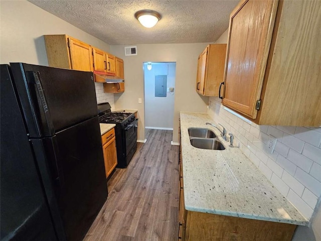 6301 Creekford Dr, Lithonia, GA 30058 - kitchen with visible vents, black appliances, wood finished floors, a sink, and backsplash