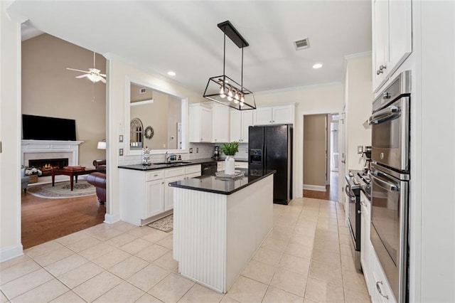 1125 Fairview Club Cir, Dacula, GA 30019 - kitchen featuring black appliances, dark countertops, light tile patterned flooring, ceiling fan, and a lit fireplace