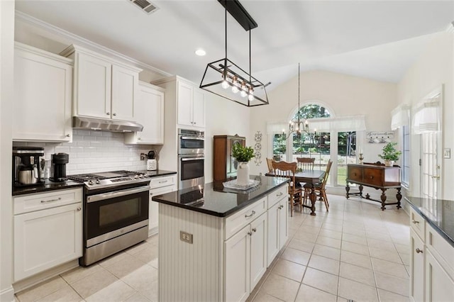 1125 Fairview Club Cir, Dacula, GA 30019 - kitchen featuring appliances with stainless steel finishes, under cabinet range hood, light tile patterned floors, decorative backsplash, and vaulted ceiling