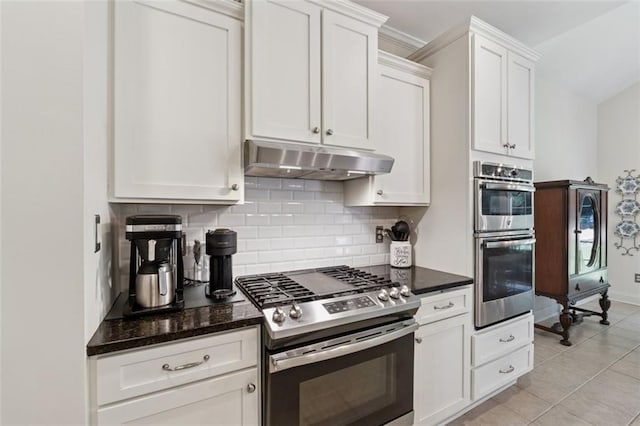 1125 Fairview Club Cir, Dacula, GA 30019 - kitchen featuring stainless steel appliances, under cabinet range hood, backsplash, white cabinets, and dark stone counters