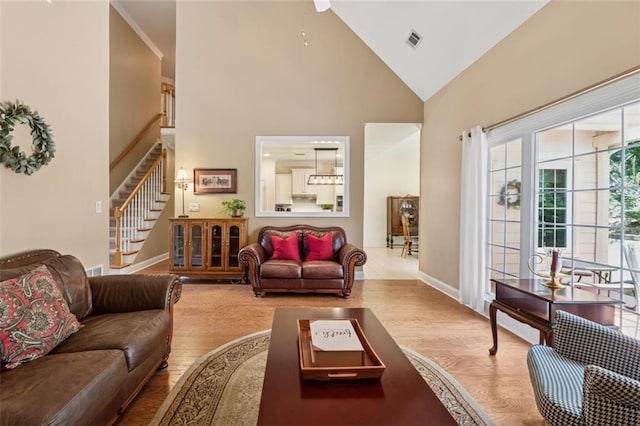 1125 Fairview Club Cir, Dacula, GA 30019 - living room featuring high vaulted ceiling, stairs, and wood finished floors