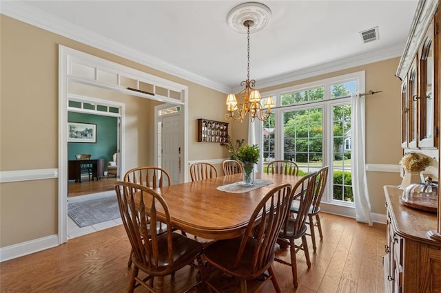 1125 Fairview Club Cir, Dacula, GA 30019 - dining space featuring light wood finished floors, crown molding, and a chandelier