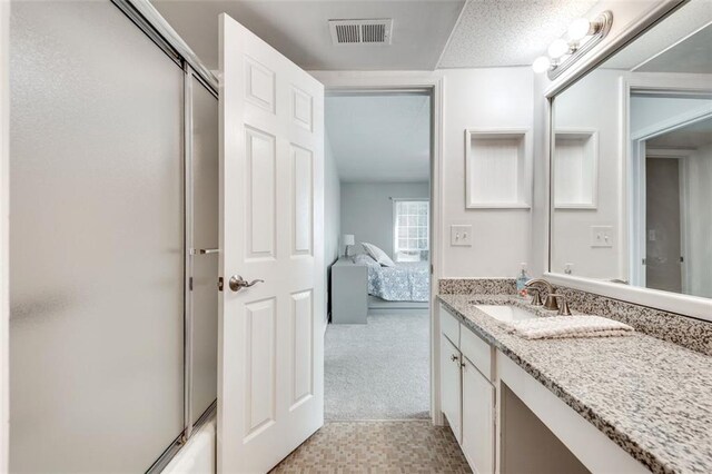 bathroom featuring ensuite bath, vanity, and visible vents