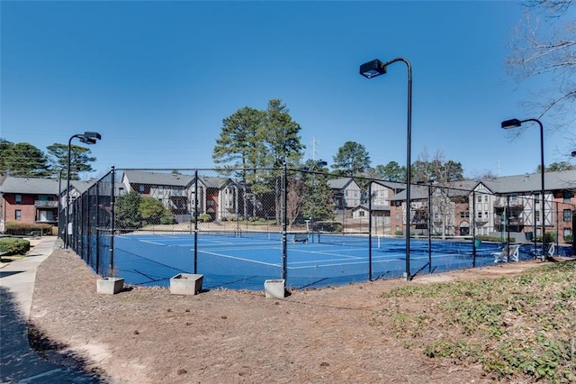 view of sport court with a residential view and fence