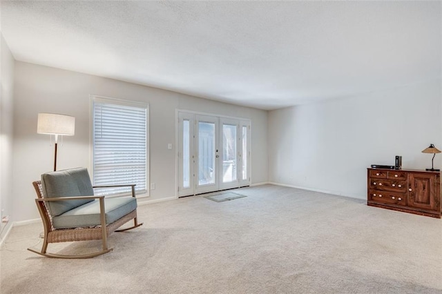 living area with baseboards, carpet flooring, and french doors