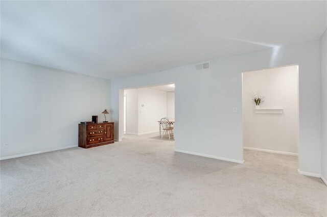 carpeted spare room with baseboards and visible vents