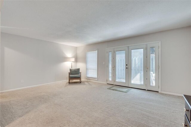 unfurnished room with carpet floors, french doors, and baseboards