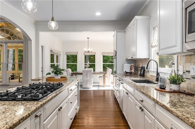 4679 Glenshire Pl, Dunwoody, GA 30338 - kitchen with stainless steel appliances, a sink, white cabinets, tasteful backsplash, and crown molding