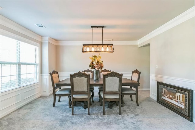 carpeted dining space featuring ornamental molding