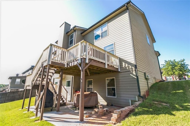 back of property with a patio area, a lawn, and a deck