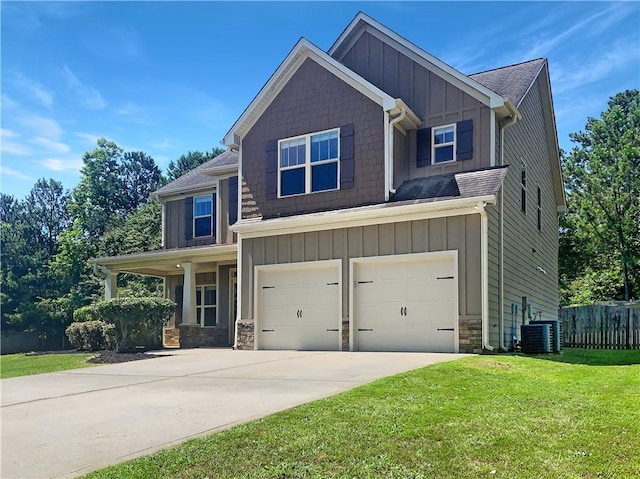 craftsman-style home featuring cooling unit, a front yard, and a garage