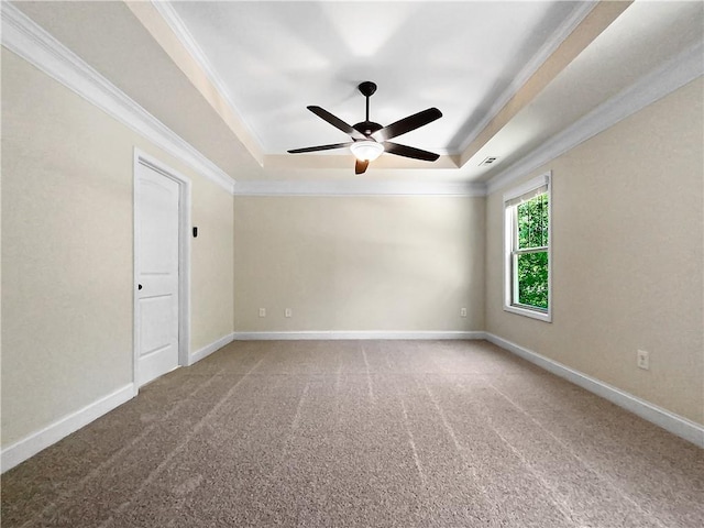 carpeted spare room with ceiling fan, a raised ceiling, and ornamental molding