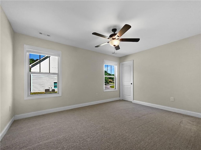 carpeted spare room featuring ceiling fan