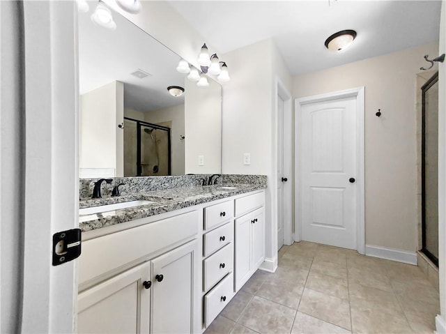 bathroom featuring tile patterned floors, a shower with door, and vanity