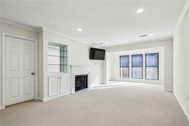 unfurnished living room featuring carpet floors, a fireplace with flush hearth, visible vents, and crown molding