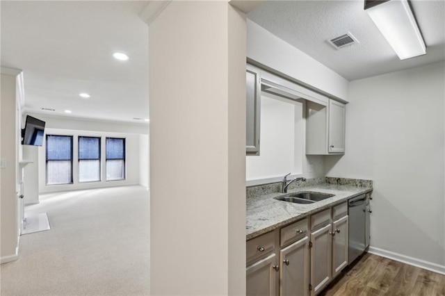 kitchen featuring recessed lighting, visible vents, stainless steel dishwasher, open floor plan, and a sink