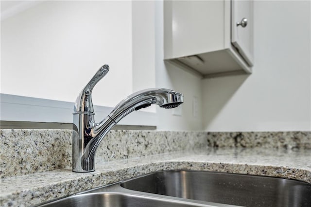 details with a sink and light stone countertops