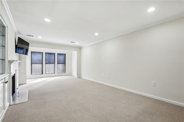 unfurnished living room with recessed lighting, light colored carpet, a fireplace with flush hearth, baseboards, and crown molding