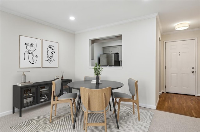 carpeted dining space featuring recessed lighting, crown molding, and baseboards