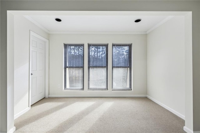 empty room with ornamental molding, carpet, and baseboards