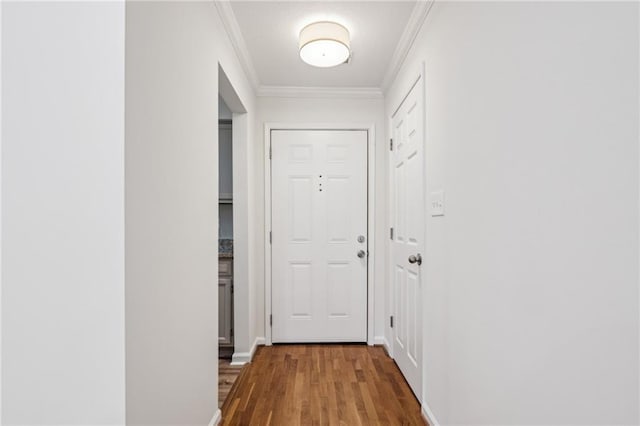 doorway to outside with ornamental molding, wood finished floors, and baseboards