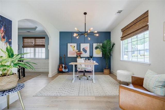 office featuring visible vents, a chandelier, baseboards, wood finished floors, and arched walkways