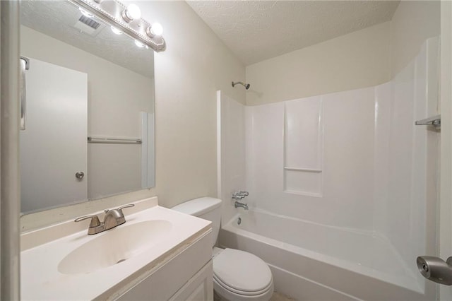 full bathroom featuring vanity, washtub / shower combination, a textured ceiling, and toilet