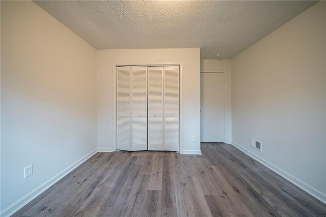 unfurnished bedroom with a closet, light hardwood / wood-style flooring, and a textured ceiling