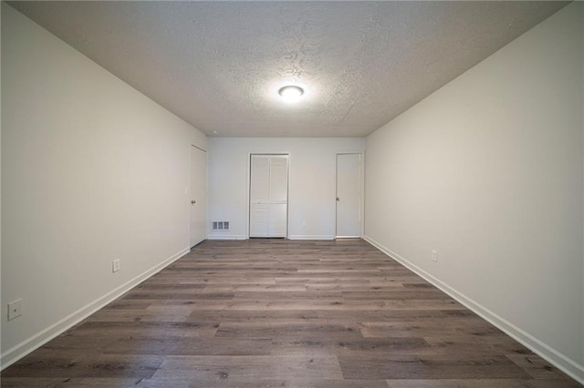 unfurnished bedroom with hardwood / wood-style flooring, a closet, and a textured ceiling