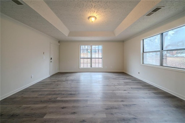 unfurnished room with dark hardwood / wood-style floors, a raised ceiling, and a textured ceiling