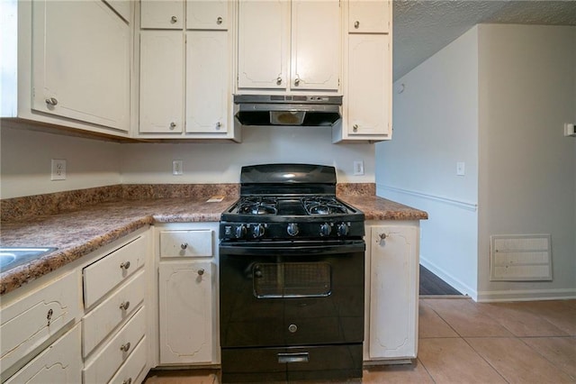 kitchen with white cabinetry, light tile patterned floors, gas stove, and a textured ceiling