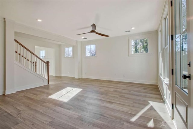 spare room featuring ceiling fan, light hardwood / wood-style floors, and a healthy amount of sunlight