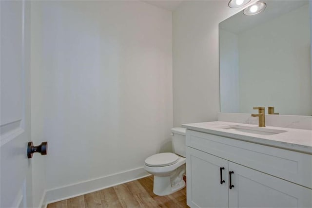 bathroom with hardwood / wood-style flooring, vanity, and toilet