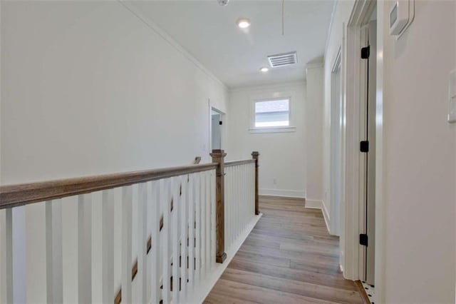 corridor featuring crown molding and light wood-type flooring