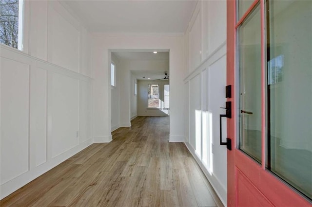 hall featuring crown molding and light hardwood / wood-style floors