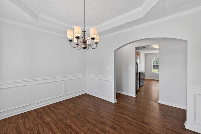 563 Bailey Dr, Jefferson, GA 30549 - empty room featuring arched walkways, a tray ceiling, dark wood-type flooring, a chandelier, and ornamental molding