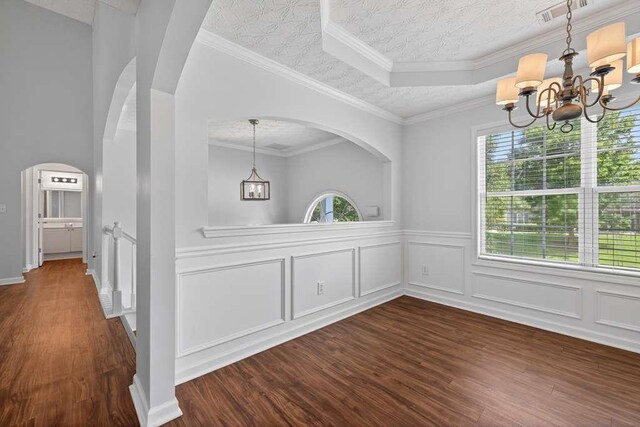 563 Bailey Dr, Jefferson, GA 30549 - unfurnished dining area with a chandelier, dark wood-style flooring, arched walkways, and wainscoting