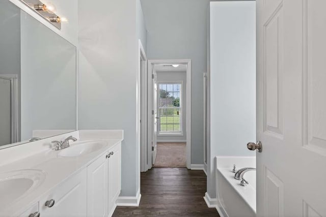 563 Bailey Dr, Jefferson, GA 30549 - full bathroom with double vanity, wood finished floors, and a garden tub
