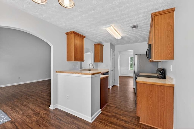 563 Bailey Dr, Jefferson, GA 30549 - kitchen featuring light countertops, dark wood-style floors, brown cabinetry, and black microwave
