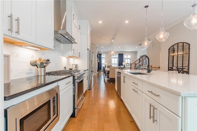 1964 Attell Way, Decatur, GA 30033 - kitchen with wall chimney exhaust hood, a sink, stainless steel appliances, open floor plan, and light wood-style flooring