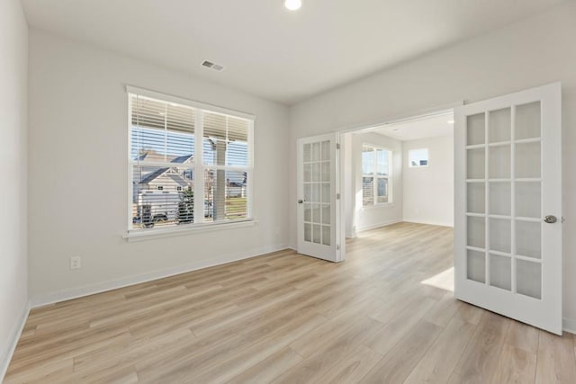 unfurnished room with light hardwood / wood-style flooring and french doors