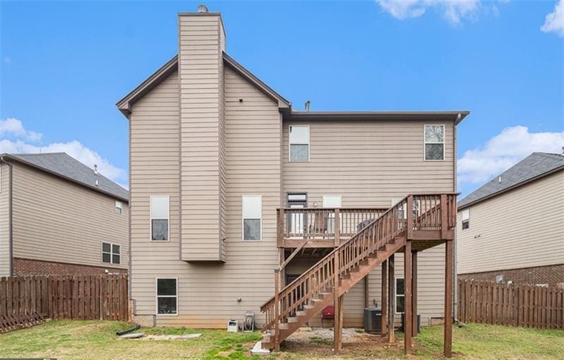 949 Nevis Way, Mcdonough, GA 30253 - back of property featuring a wooden deck, stairway, central AC unit, and a chimney