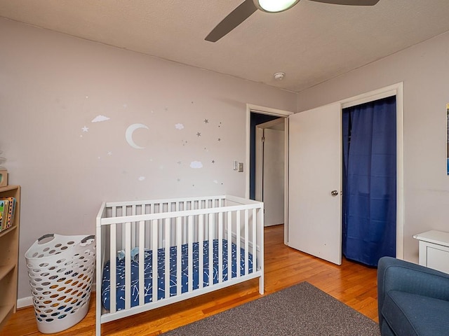 bedroom with hardwood / wood-style floors, a closet, and ceiling fan