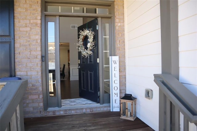 view of exterior entry with stone siding and visible vents