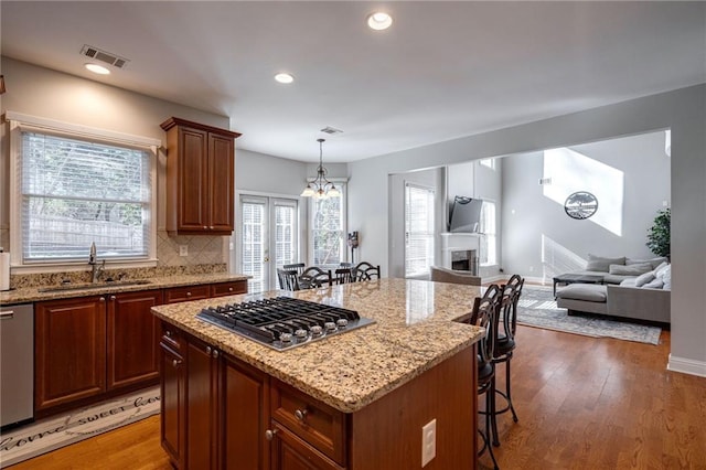 kitchen featuring a kitchen island, sink, a kitchen breakfast bar, and appliances with stainless steel finishes