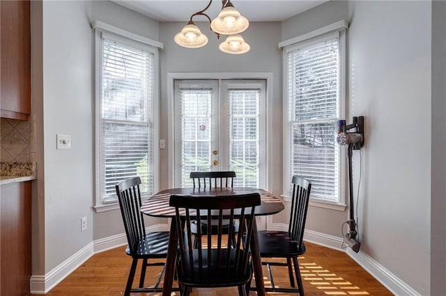 dining space with french doors and wood-type flooring