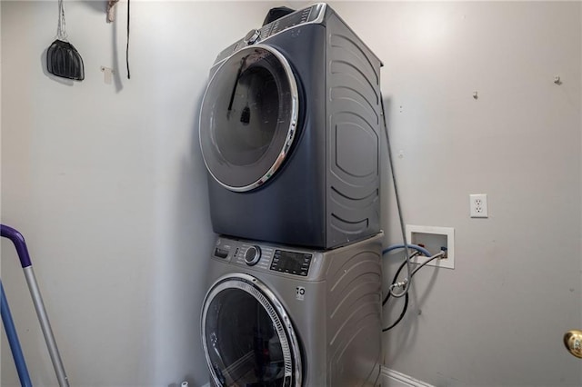 washroom featuring stacked washer / drying machine